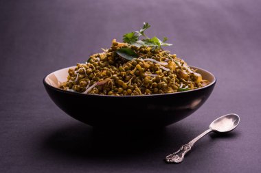 Mugachi Usal ya da Baharatlı Moong Sabzi 'yi filizlendirdi. Renkli arka planda bir kasede servis edilmiş. Seçici odak