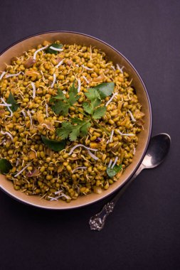 Mugachi Usal ya da Baharatlı Moong Sabzi 'yi filizlendirdi. Renkli arka planda bir kasede servis edilmiş. Seçici odak