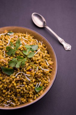 Mugachi Usal ya da Baharatlı Moong Sabzi 'yi filizlendirdi. Renkli arka planda bir kasede servis edilmiş. Seçici odak