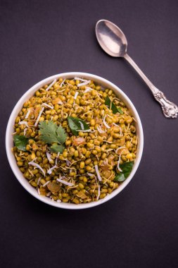 Mugachi Usal ya da Baharatlı Moong Sabzi 'yi filizlendirdi. Renkli arka planda bir kasede servis edilmiş. Seçici odak