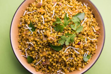 Mugachi Usal ya da Baharatlı Moong Sabzi 'yi filizlendirdi. Renkli arka planda bir kasede servis edilmiş. Seçici odak