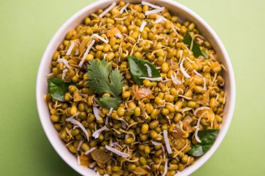 Mugachi Usal ya da Baharatlı Moong Sabzi 'yi filizlendirdi. Renkli arka planda bir kasede servis edilmiş. Seçici odak