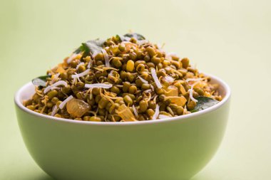 Mugachi Usal ya da Baharatlı Moong Sabzi 'yi filizlendirdi. Renkli arka planda bir kasede servis edilmiş. Seçici odak