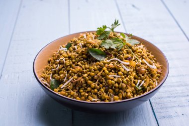 Mugachi Usal ya da Baharatlı Moong Sabzi 'yi filizlendirdi. Ahşap arka planda bir kasede servis edilmiş. Seçici odak