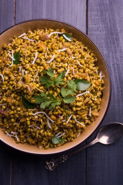 Mugachi Usal ya da Baharatlı Moong Sabzi 'yi filizlendirdi. Ahşap arka planda bir kasede servis edilmiş. Seçici odak