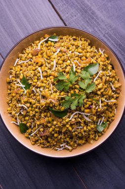 Mugachi Usal ya da Baharatlı Moong Sabzi 'yi filizlendirdi. Ahşap arka planda bir kasede servis edilmiş. Seçici odak