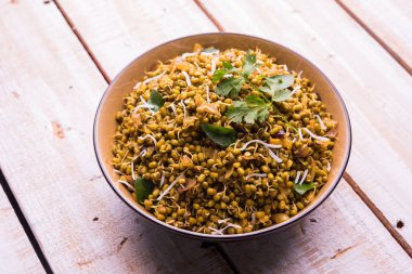 Mugachi Usal ya da Baharatlı Moong Sabzi 'yi filizlendirdi. Ahşap arka planda bir kasede servis edilmiş. Seçici odak