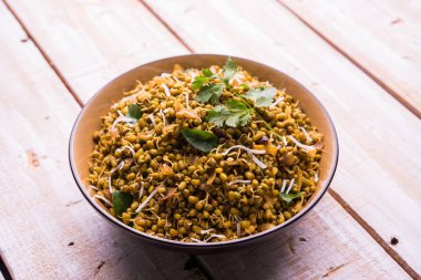 Mugachi Usal ya da Baharatlı Moong Sabzi 'yi filizlendirdi. Ahşap arka planda bir kasede servis edilmiş. Seçici odak