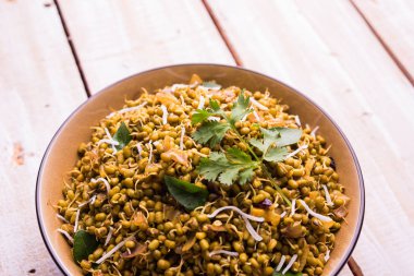 Mugachi Usal ya da Baharatlı Moong Sabzi 'yi filizlendirdi. Ahşap arka planda bir kasede servis edilmiş. Seçici odak