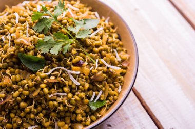 Mugachi Usal ya da Baharatlı Moong Sabzi 'yi filizlendirdi. Ahşap arka planda bir kasede servis edilmiş. Seçici odak