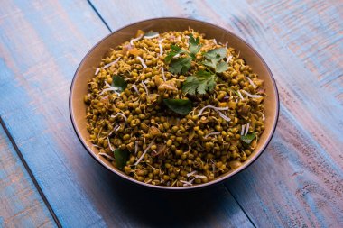 Mugachi Usal ya da Baharatlı Moong Sabzi 'yi filizlendirdi. Ahşap arka planda bir kasede servis edilmiş. Seçici odak