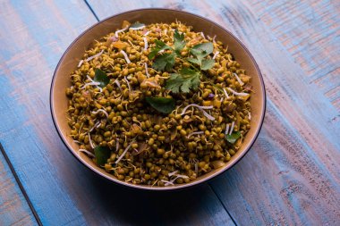Mugachi Usal ya da Baharatlı Moong Sabzi 'yi filizlendirdi. Ahşap arka planda bir kasede servis edilmiş. Seçici odak
