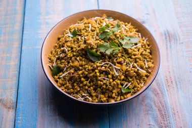 Mugachi Usal ya da Baharatlı Moong Sabzi 'yi filizlendirdi. Ahşap arka planda bir kasede servis edilmiş. Seçici odak