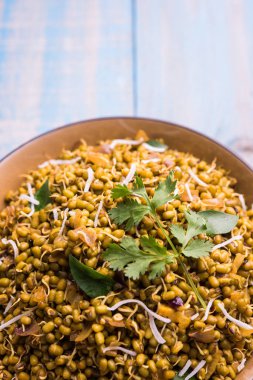 Mugachi Usal ya da Baharatlı Moong Sabzi 'yi filizlendirdi. Ahşap arka planda bir kasede servis edilmiş. Seçici odak