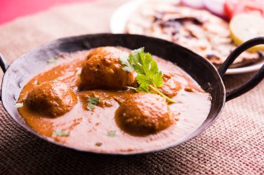 Kaşmir Dum Aloo ya da baharatlı patatesli köri, taze krema ve kişniş ile süslenmiş. Renkli bir geçmişi olan, Naan / Roti ile birlikte bir Karahi 'de hizmet vermiş. Seçici odak