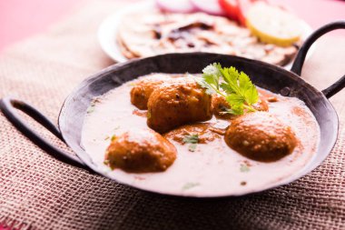 Kaşmir Dum Aloo ya da baharatlı patatesli köri, taze krema ve kişniş ile süslenmiş. Renkli bir geçmişi olan, Naan / Roti ile birlikte bir Karahi 'de hizmet vermiş. Seçici odak