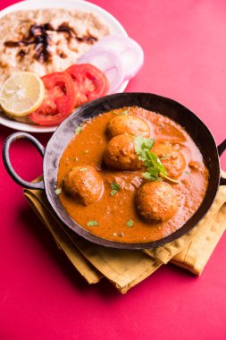 Kaşmir Dum Aloo ya da baharatlı patatesli köri, taze krema ve kişniş ile süslenmiş. Renkli bir geçmişi olan, Naan / Roti ile birlikte bir Karahi 'de hizmet vermiş. Seçici odak