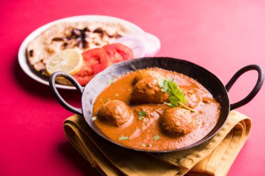 Kaşmir Dum Aloo ya da baharatlı patatesli köri, taze krema ve kişniş ile süslenmiş. Renkli bir geçmişi olan, Naan / Roti ile birlikte bir Karahi 'de hizmet vermiş. Seçici odak