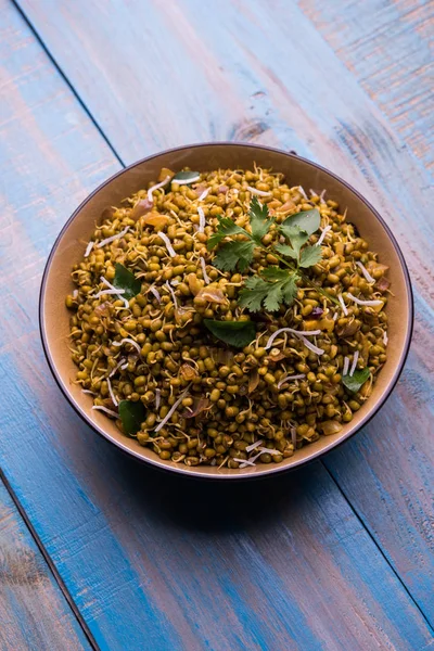 Mugachi Usal ya da Baharatlı Moong Sabzi 'yi filizlendirdi. Ahşap arka planda bir kasede servis edilmiş. Seçici odak