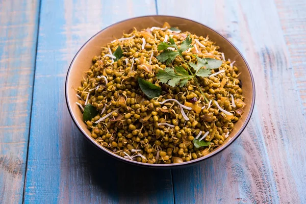 Mugachi Usal ya da Baharatlı Moong Sabzi 'yi filizlendirdi. Ahşap arka planda bir kasede servis edilmiş. Seçici odak