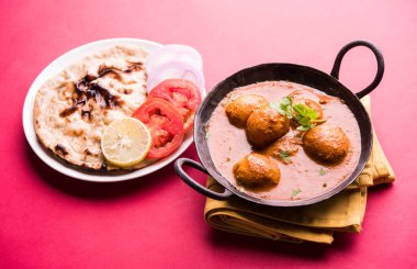 Kaşmir Dum Aloo ya da baharatlı patatesli köri, taze krema ve kişniş ile süslenmiş. Renkli bir geçmişi olan, Naan / Roti ile birlikte bir Karahi 'de hizmet vermiş. Seçici odak