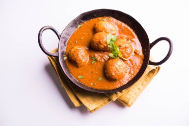 Kızartma tavasında taze pişirilmiş baharatlı patates körisi mi yoksa tandır roti veya naan veya Hint ekmeği veya chapati ve yeşil salata ile servis edilen sıcak ve baharatlı Dum aloo mu?