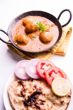 Kaşmir Dum Aloo ya da baharatlı patatesli köri, taze krema ve kişniş ile süslenmiş. Renkli bir geçmişi olan, Naan / Roti ile birlikte bir Karahi 'de hizmet vermiş. Seçici odak