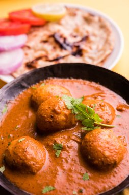 Kaşmir Dum Aloo ya da baharatlı patatesli köri, taze krema ve kişniş ile süslenmiş. Renkli bir geçmişi olan, Naan / Roti ile birlikte bir Karahi 'de hizmet vermiş. Seçici odak