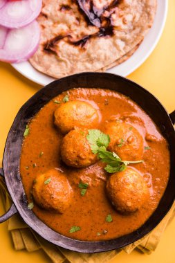 Kaşmir Dum Aloo ya da baharatlı patatesli köri, taze krema ve kişniş ile süslenmiş. Renkli bir geçmişi olan, Naan / Roti ile birlikte bir Karahi 'de hizmet vermiş. Seçici odak