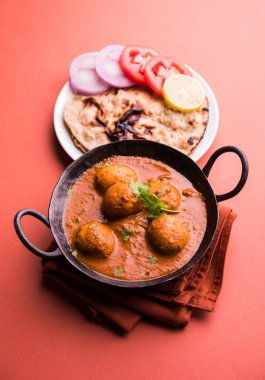 Kaşmir Dum Aloo ya da baharatlı patatesli köri, taze krema ve kişniş ile süslenmiş. Renkli bir geçmişi olan, Naan / Roti ile birlikte bir Karahi 'de hizmet vermiş. Seçici odak
