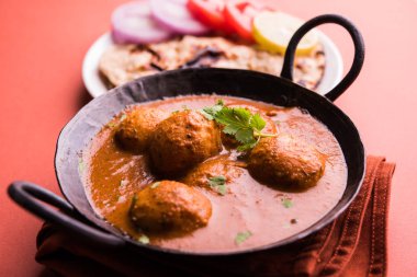Kaşmir Dum Aloo ya da baharatlı patatesli köri, taze krema ve kişniş ile süslenmiş. Renkli bir geçmişi olan, Naan / Roti ile birlikte bir Karahi 'de hizmet vermiş. Seçici odak