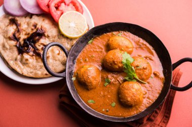 Kaşmir Dum Aloo ya da baharatlı patatesli köri, taze krema ve kişniş ile süslenmiş. Renkli bir geçmişi olan, Naan / Roti ile birlikte bir Karahi 'de hizmet vermiş. Seçici odak