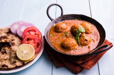 Kızartma tavasında taze pişirilmiş baharatlı patates körisi mi yoksa tandır roti veya naan veya Hint ekmeği veya chapati ve yeşil salata ile servis edilen sıcak ve baharatlı Dum aloo mu?