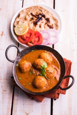 Kızartma tavasında taze pişirilmiş baharatlı patates körisi mi yoksa tandır roti veya naan veya Hint ekmeği veya chapati ve yeşil salata ile servis edilen sıcak ve baharatlı Dum aloo mu?