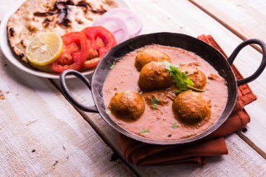 Kızartma tavasında taze pişirilmiş baharatlı patates körisi mi yoksa tandır roti veya naan veya Hint ekmeği veya chapati ve yeşil salata ile servis edilen sıcak ve baharatlı Dum aloo mu?