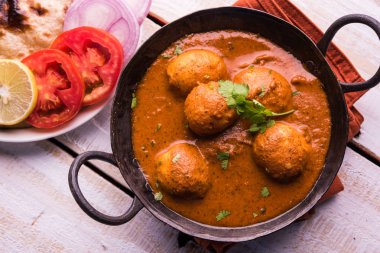 Kızartma tavasında taze pişirilmiş baharatlı patates körisi mi yoksa tandır roti veya naan veya Hint ekmeği veya chapati ve yeşil salata ile servis edilen sıcak ve baharatlı Dum aloo mu?