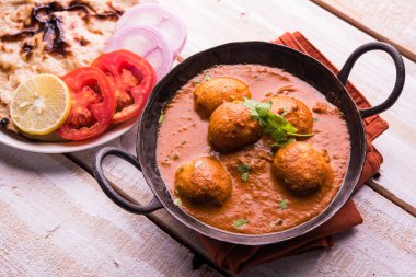 Kızartma tavasında taze pişirilmiş baharatlı patates körisi mi yoksa tandır roti veya naan veya Hint ekmeği veya chapati ve yeşil salata ile servis edilen sıcak ve baharatlı Dum aloo mu?