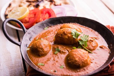 Kızartma tavasında taze pişirilmiş baharatlı patates körisi mi yoksa tandır roti veya naan veya Hint ekmeği veya chapati ve yeşil salata ile servis edilen sıcak ve baharatlı Dum aloo mu?