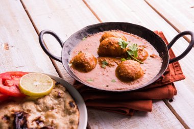 Kızartma tavasında taze pişirilmiş baharatlı patates körisi mi yoksa tandır roti veya naan veya Hint ekmeği veya chapati ve yeşil salata ile servis edilen sıcak ve baharatlı Dum aloo mu?