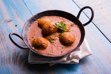 Kızartma tavasında taze pişirilmiş baharatlı patates körisi mi yoksa tandır roti veya naan veya Hint ekmeği veya chapati ve yeşil salata ile servis edilen sıcak ve baharatlı Dum aloo mu?