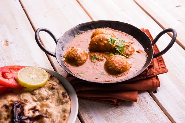 Kızartma tavasında taze pişirilmiş baharatlı patates körisi mi yoksa tandır roti veya naan veya Hint ekmeği veya chapati ve yeşil salata ile servis edilen sıcak ve baharatlı Dum aloo mu?