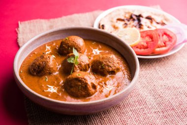 Kızartma tavasında taze pişirilmiş baharatlı patates körisi mi yoksa tandır roti veya naan veya Hint ekmeği veya chapati ve yeşil salata ile servis edilen sıcak ve baharatlı Dum aloo mu?