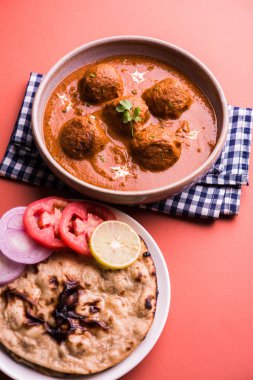 Kızartma tavasında taze pişirilmiş baharatlı patates körisi mi yoksa tandır roti veya naan veya Hint ekmeği veya chapati ve yeşil salata ile servis edilen sıcak ve baharatlı Dum aloo mu?