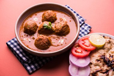 Kızartma tavasında taze pişirilmiş baharatlı patates körisi mi yoksa tandır roti veya naan veya Hint ekmeği veya chapati ve yeşil salata ile servis edilen sıcak ve baharatlı Dum aloo mu?