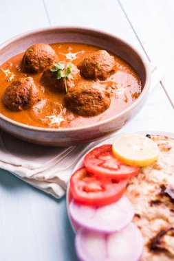 Kızartma tavasında taze pişirilmiş baharatlı patates körisi mi yoksa tandır roti veya naan veya Hint ekmeği veya chapati ve yeşil salata ile servis edilen sıcak ve baharatlı Dum aloo mu?