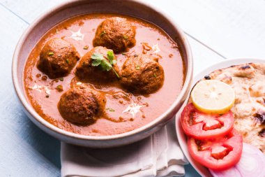 Kızartma tavasında taze pişirilmiş baharatlı patates körisi mi yoksa tandır roti veya naan veya Hint ekmeği veya chapati ve yeşil salata ile servis edilen sıcak ve baharatlı Dum aloo mu?