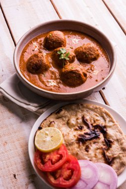 Kızartma tavasında taze pişirilmiş baharatlı patates körisi mi yoksa tandır roti veya naan veya Hint ekmeği veya chapati ve yeşil salata ile servis edilen sıcak ve baharatlı Dum aloo mu?