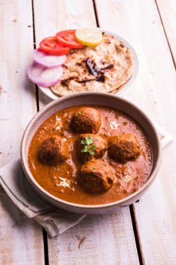 Kızartma tavasında taze pişirilmiş baharatlı patates körisi mi yoksa tandır roti veya naan veya Hint ekmeği veya chapati ve yeşil salata ile servis edilen sıcak ve baharatlı Dum aloo mu?