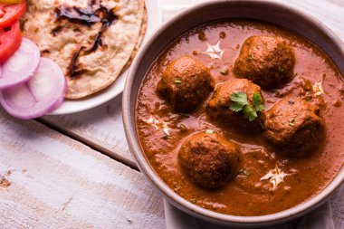 Kızartma tavasında taze pişirilmiş baharatlı patates körisi mi yoksa tandır roti veya naan veya Hint ekmeği veya chapati ve yeşil salata ile servis edilen sıcak ve baharatlı Dum aloo mu?