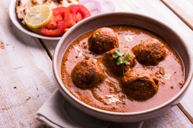 Kızartma tavasında taze pişirilmiş baharatlı patates körisi mi yoksa tandır roti veya naan veya Hint ekmeği veya chapati ve yeşil salata ile servis edilen sıcak ve baharatlı Dum aloo mu?